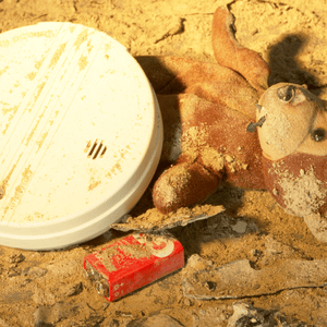 Smoke detector and toy in ashes